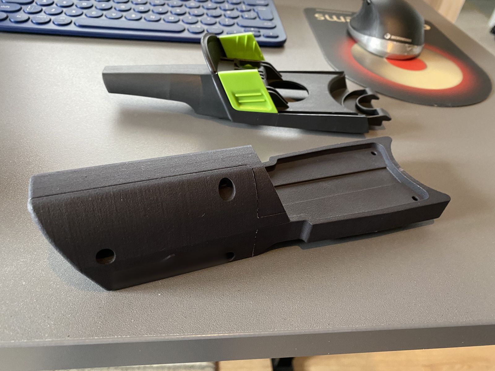 3D-printed prototype housing parts with green clips on a desk
